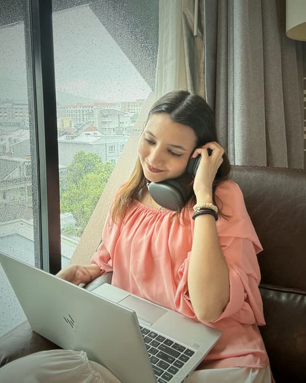 Mysbah on a call while working on her laptop